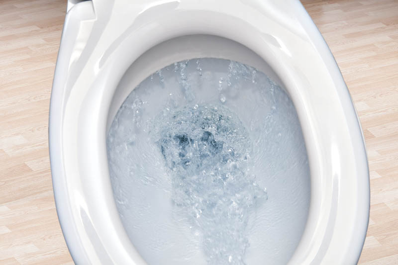 Closeup of water being flushed down toilet